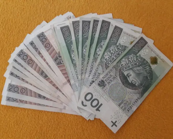 Stos banknotów 100 i 200 zł, gotowy na darowiznę dla dziecka.