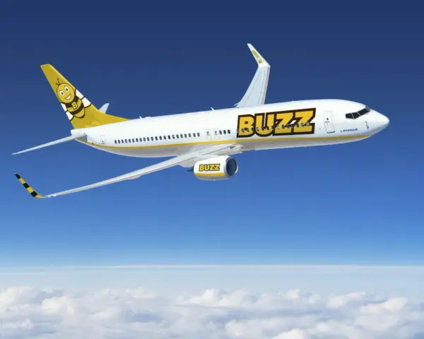 Samolot Buzz, należący do Ryanair, leci nad chmurami. Idealny na wakacje, zabierze Twój bagaż w słoneczne miejsce.