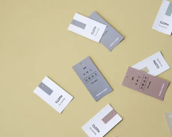 Etykiety odzieżowe z napisem "CLOTH for real life" i symbolami pielęgnacji. Nawet syntetyki mogą być wysokiej jakości.