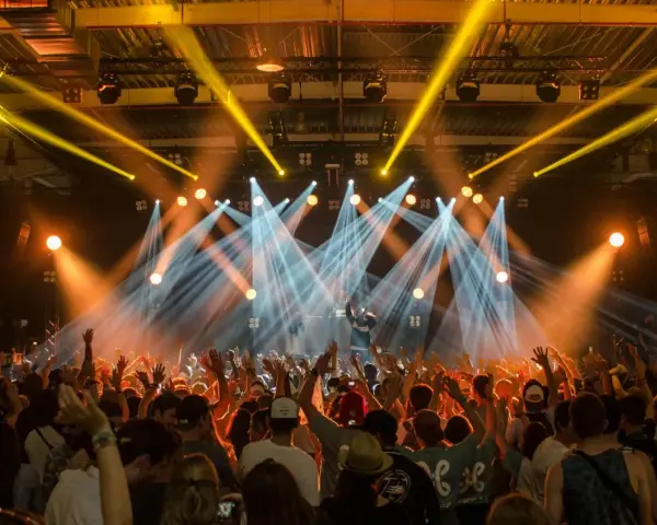Tłumy na festiwalu muzycznym szaleją pod światłami sceny.