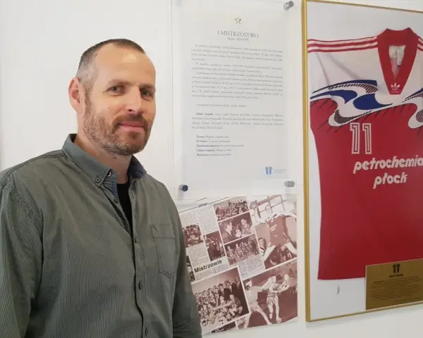 Michał Dębski na tle koszulki "Petrochemia Płock" z numerem 11, upamiętniającej mistrzostwo Polski w sezonie 1994/1995.