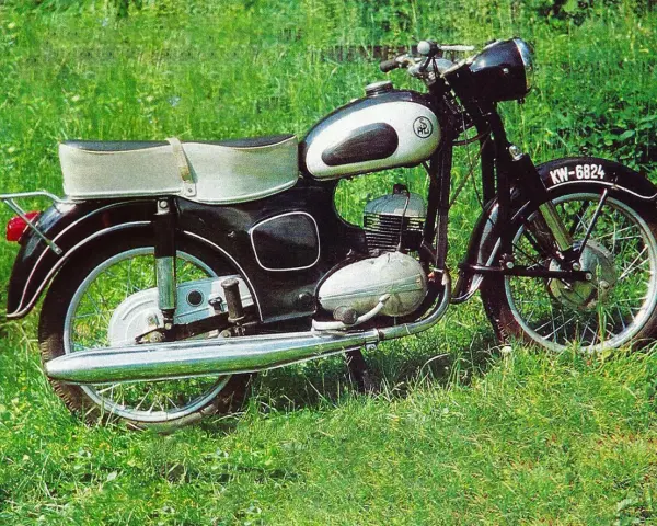 Klasyczny motocykl SHL M11 na tle zielonej trawy. Poznaj jego shl m11 dane techniczne i poczuj ducha minionej epoki.