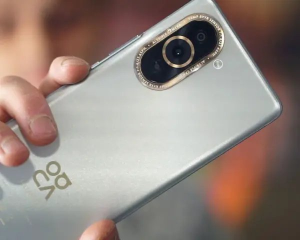 Dłoń trzyma srebrny Huawei Nova 10 Pro, ukazując moduł potrójnego aparatu z 50MP RYYB sensorem.