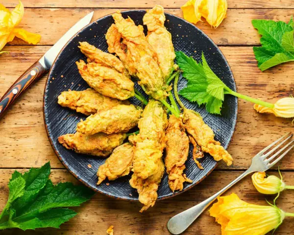 Fiori di zucca in friggitrice ad aria, dorati e croccanti, pronti per essere gustati.