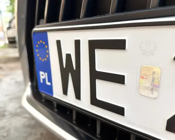Nowe tablice rejestracyjne z unijnym niebieskim paskiem i godłem Polski. Litery "WE" i hologram.
