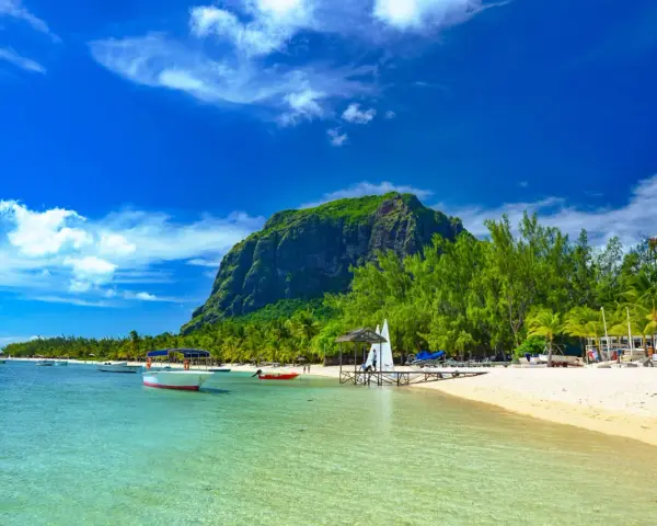 Rajskie plaże Mauritiusa: turkusowa woda, biały piasek, palmy i majestatyczna góra Le Morne Brabant.