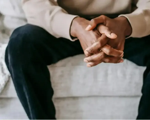 Mains jointes d'un homme, une posture qui peut exprimer le désir, la contemplation ou l'attente.