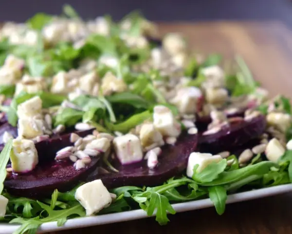 Eleganckie carpaccio z buraka z rukolą, serem feta i pestkami słonecznika.