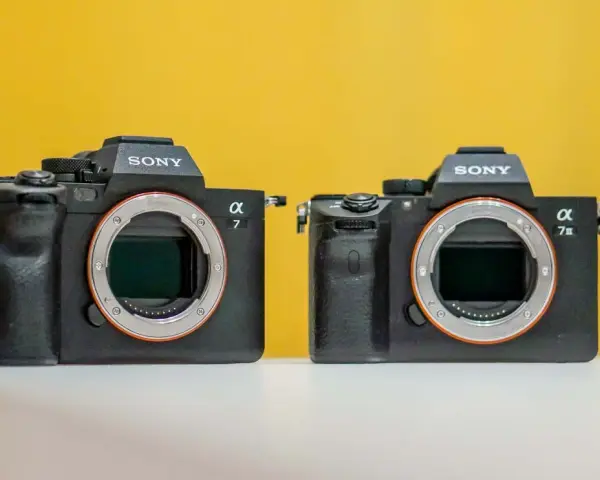 Dwa aparaty Sony Alpha 7, w tym model Sony a7 IIIs, na żółtym tle.