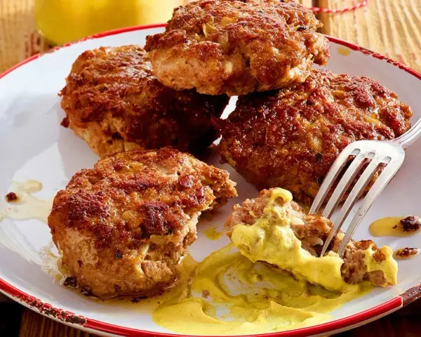 Leckere Frikadellen, goldbraun gebraten, mit Senf auf einem Teller. Ein perfektes Frikadellen Rezept für jeden Anlass.