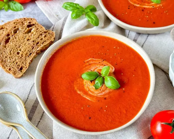 Cremige Tomatensuppe, ein tolles Rezept mit frischen Tomaten, garniert mit Basilikum und einem Klecks Sahne. Dazu knuspriges Brot.