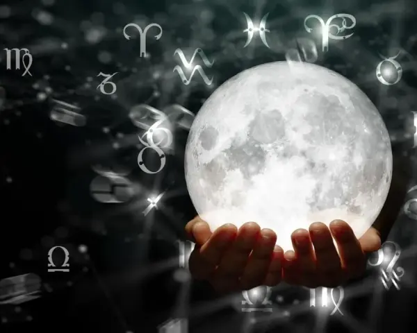 Dłonie trzymające jasną pełnię księżyca, otoczone symbolami zodiaku. To może być zapowiedź magicznej pełni marzec 2026.