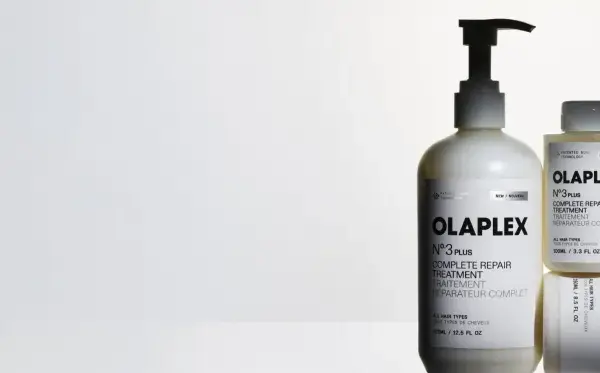 Tres botellas de Olaplex N°3, tratamiento para pelo seco o mojado, en un fondo blanco.