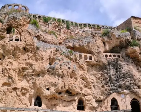 Antigua ciudad excavada en roca, con arcos y ventanas en las cuevas. Un lugar histórico que parece una cascada de piedra.