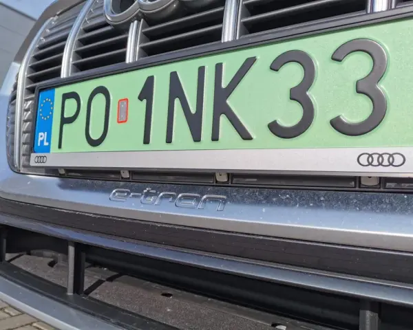 Zielone tablice rejestracyjne z numerem PO 1NK33 na samochodzie Audi e-tron.