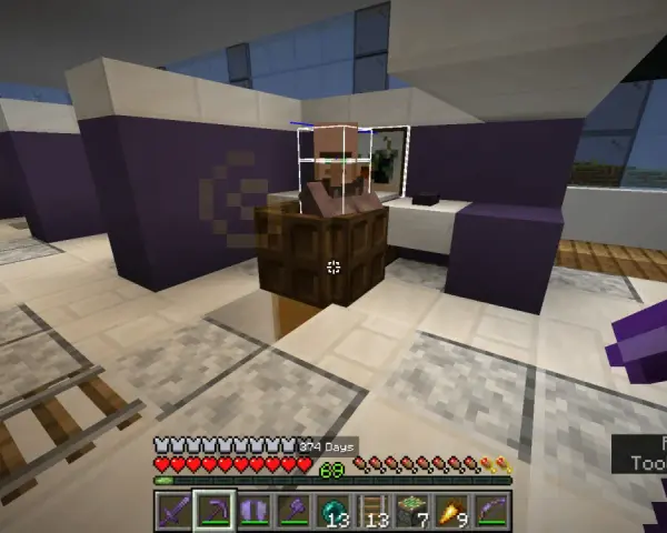 Aldeano Minecraft en su puesto de trabajo, rodeado de bloques morados y blancos. El jugador sostiene un pico de diamante.