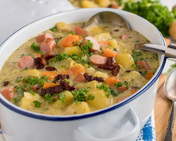 Gęsta zupa ziemniaczana z kiełbasą i boczkiem, pachnąca jak zupa ziemniaczana przepis babci. Posypana natką pietruszki.