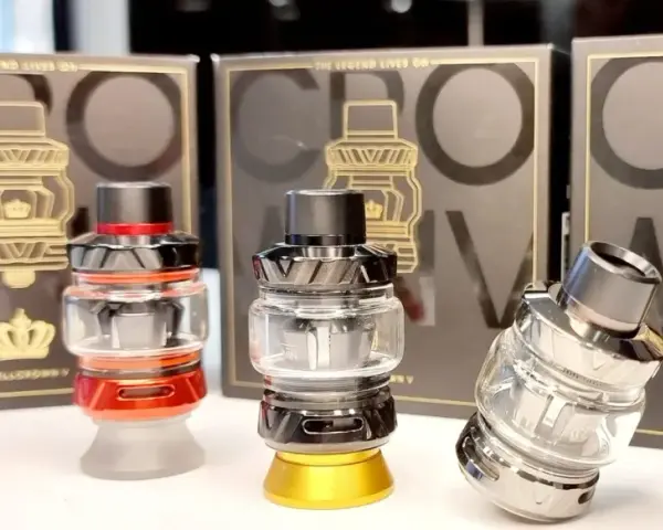 Tres atomizadores Uwell Crown V en rojo, negro y plateado, con sus cajas de fondo.
