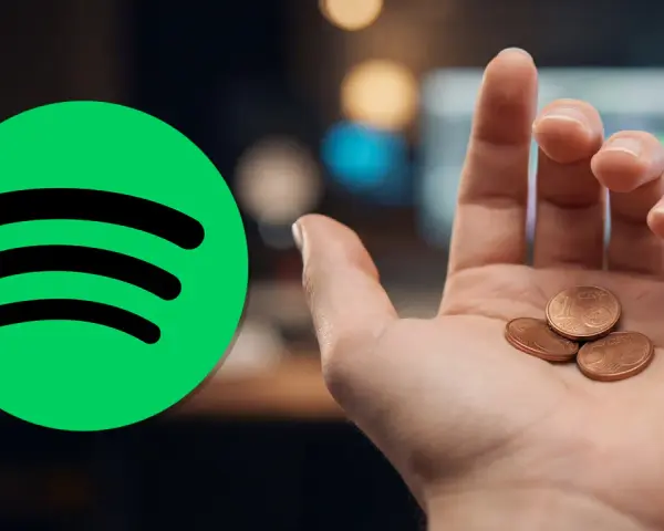 Spotify-Logo neben einer Hand mit wenigen Cent. Ein Cent pro Stream ist wenig.