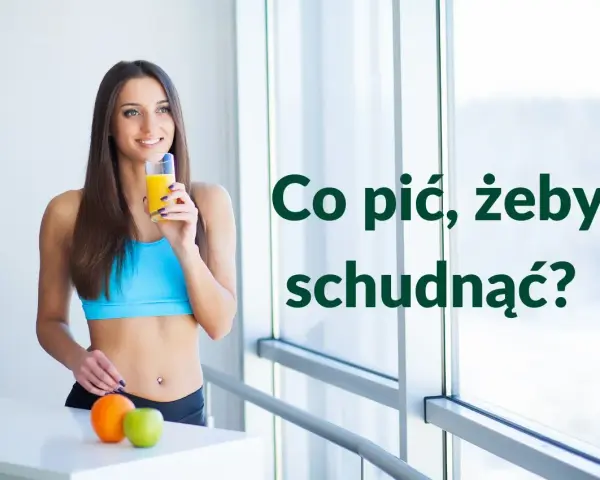Uśmiechnięta kobieta w sportowym topie pije sok, zastanawiając się, co pić żeby schudnąć. Obok pomarańcza i jabłko.