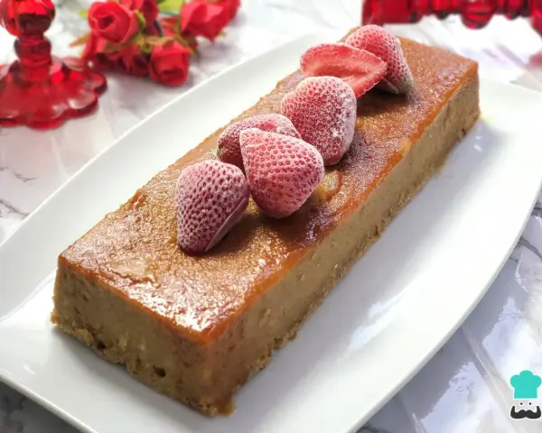 Delicioso pudin de pan casero, cubierto con fresas congeladas y un glaseado dorado.