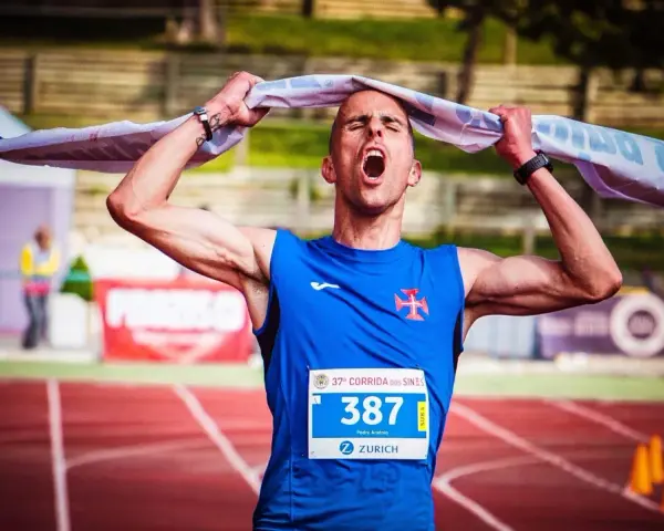 Atleta exhausto, con la boca abierta y una toalla sobre la cabeza, celebra el fin de correr una maratón.