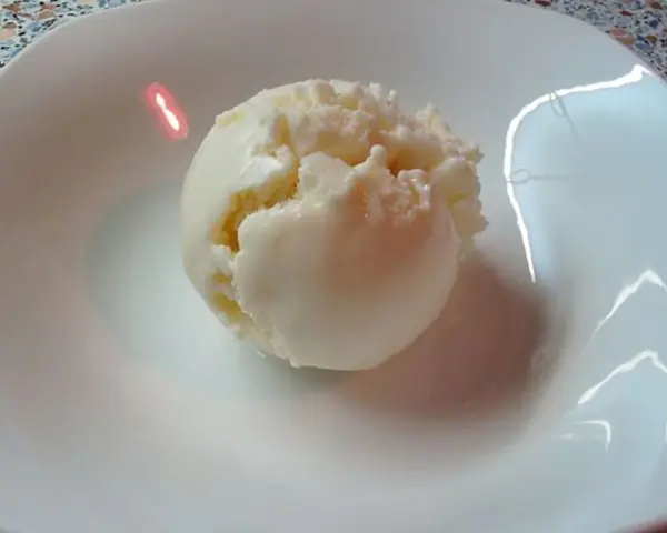 Eine Kugel cremiges Quark Eis in einer weißen Schale, bereit zum Genießen.