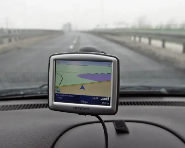 Nawigacja TomTom na desce rozdzielczej samochodu podczas jazdy w mglisty dzień.