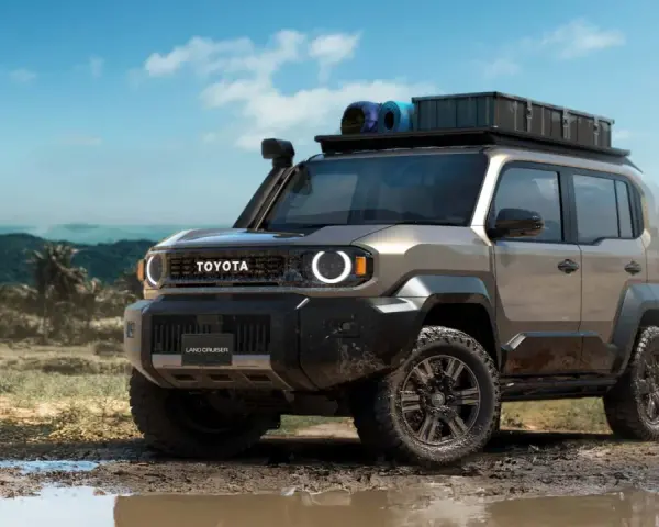 Nowy Toyota Land Cruiser 100 gotowy na przygodę, z bagażnikiem dachowym i terenowymi oponami, w błotnistym krajobrazie.