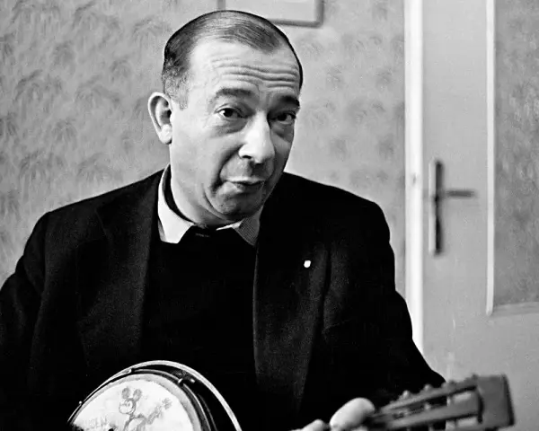 Jerzy Putrament, z gitarą w dłoniach, jakby inspirowany do tworzenia nowych utworów.