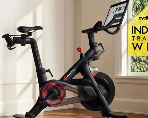A Peloton bike, perfect for indoor cycling vs spinning, sits in a bright room. A yellow graphic promotes "Indoor Training Week.