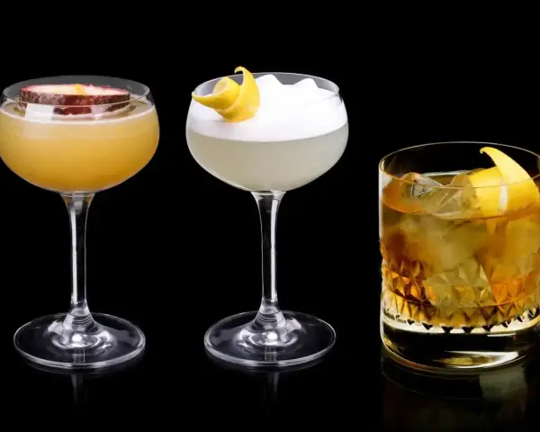 Trzy drinki: jeden z marakują, drugi z pianką i skórką cytryny, trzeci z lodem i skórką cytryny, każdy z nutą Cointreau.