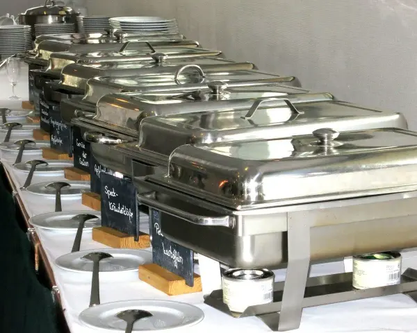 Długi rząd podgrzewaczy z jedzeniem, gotowych do serwowania. To świetny pomysł, jak otworzyć catering i zaimponować gościom.