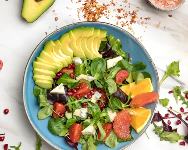Insalata di avocado fresca con pomodorini, melograno, agrumi e formaggio blu.