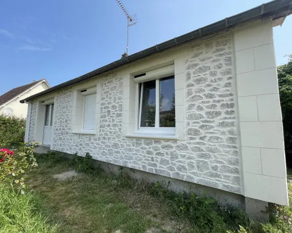 Façade de maison rénovée avec un enduit à la chaux imitant la pierre. Belle utilisation de la chaux pour un aspect authentique.