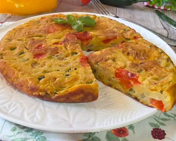 Herzhafte Frittata mit Gemüse, zubereitet in der frittata pfanne oder ofen, garniert mit Basilikum.