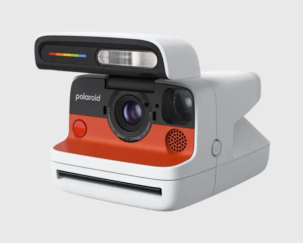 Nowoczesny aparat Polaroid z pomarańczowym akcentem i tęczowym paskiem na lampie błyskowej. To właśnie polaroid, co to za magia!