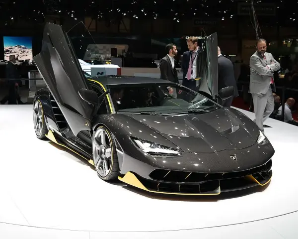 Ciemnoszary Lamborghini z otwartymi drzwiami, żółte akcenty. Zastanawiasz się, ile kosztuje Lamborghini Urus? Ten model to marzenie.