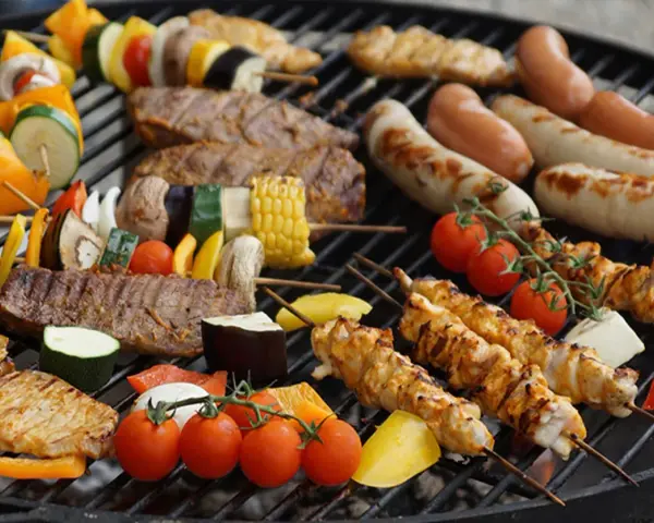 ¡Qué rico! Carne, salchichas y verduras listas para hacer una barbacoa.