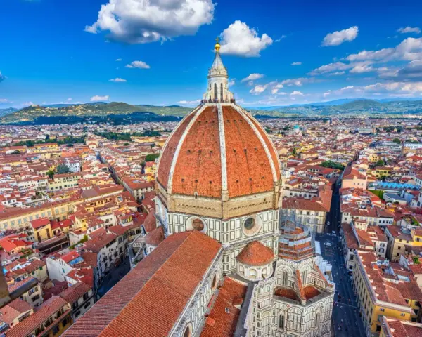 Widok na kopułę Duomo i miasto Florencja. W tle wzgórza Toskanii. To miejsce to prawdziwy florenckie muzeum pod gołym niebem.