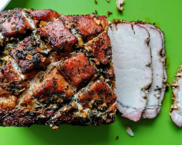 Arrosto di lonza di maiale con crosta croccante e erbe aromatiche, pronto per essere gustato. Ottima tra le lonza di maiale ricette.