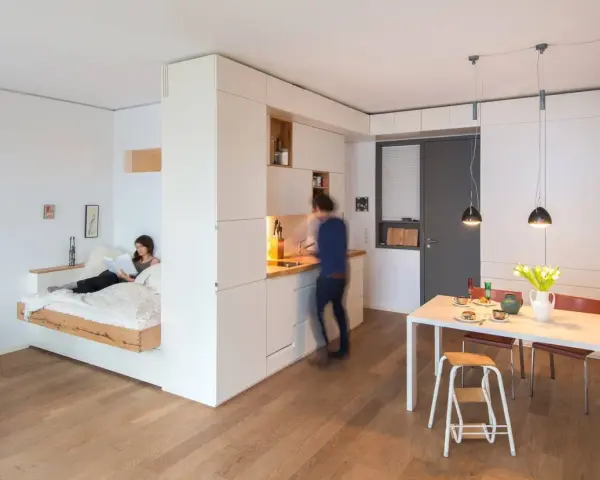 Un letto sospeso, una cucina moderna e un tavolo da pranzo creano un ambiente accogliente in queste case piccole bellissime.