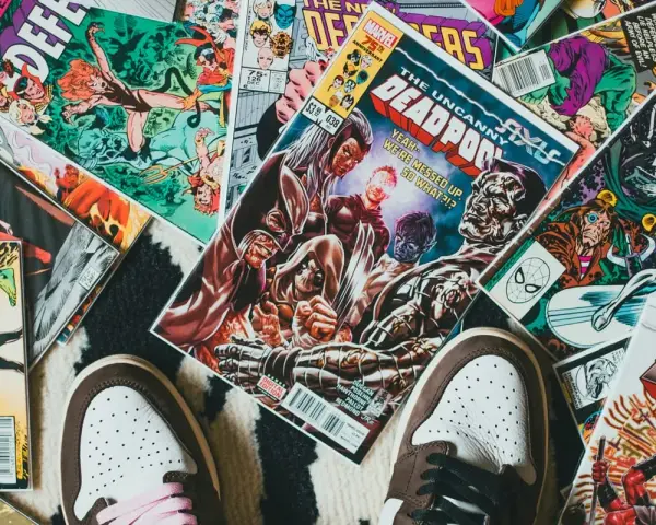 Kolekcja komiksów Marvela, w tym "The Uncanny X-Men" i "Deadpool", leży na dywanie. Idealne dla tych, którzy chcą wiedzieć, jak czytać komiksy Marvela.