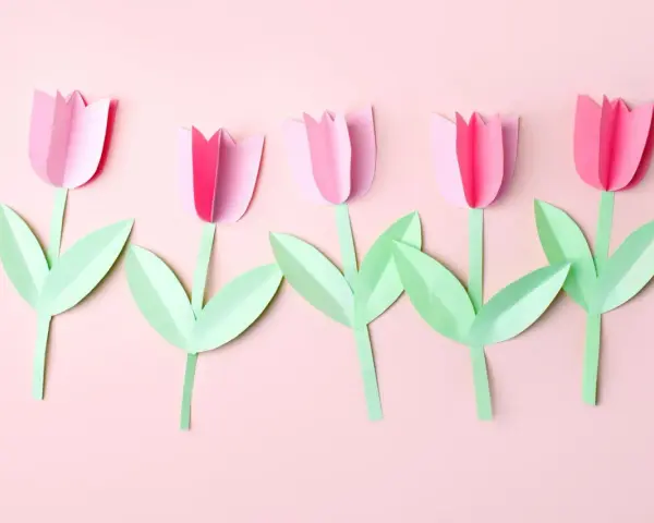 Fünf rosa Papier-Tulpen mit grünen Blättern, ein einfaches Bastelprojekt für Kinder.
