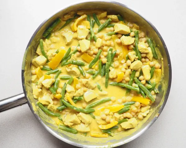 Pyszne, aromatyczne **yellow curry** z kurczakiem, fasolką szparagową i ciecierzycą w kremowym sosie.