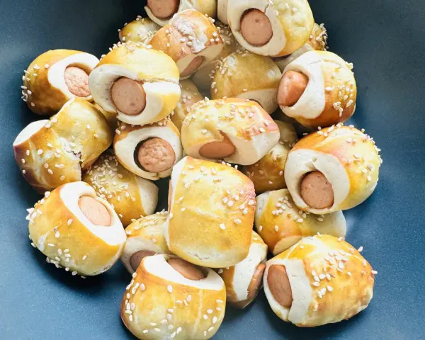 Leckere Würstchen im Teigmantel, bestreut mit Sesam. Perfekt als Fingerfood für eine Babyparty, diese Rezepte sind ein Hit!