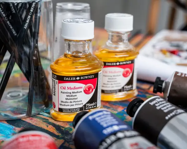 Pinceaux, flacons d'huile médium Daler Rowney et tubes de peinture à l'huile. La question "peut on mettre du gesso sur peinture à l'huile" plane sur cet atelier.