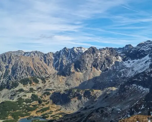 Majestatyczne Tatry z ośnieżonymi szczytami. Widok na skaliste zbocza i doliny, gdzie widać, ile ma Kasprowy Wierch.