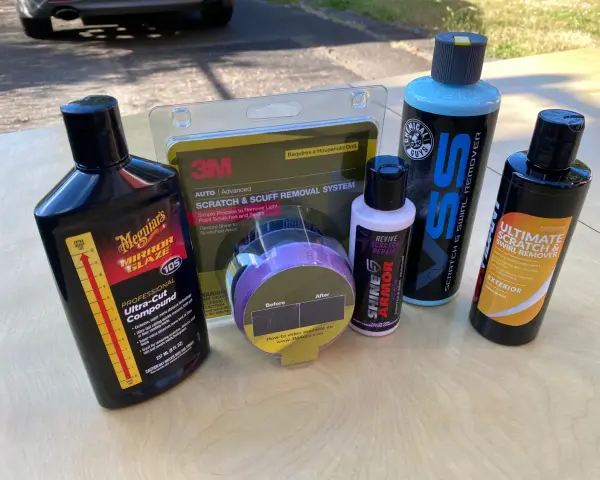 Car scratch removal products, including rubbing compound, are laid out, ready to tackle paint scratches and swirls.