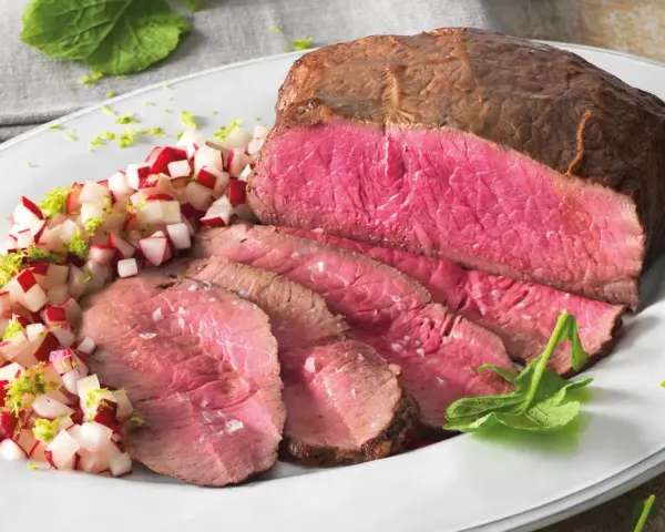 Roast beef ricetta in pentola: succulento arrosto affettato con contorno di ravanelli e scorza di lime.